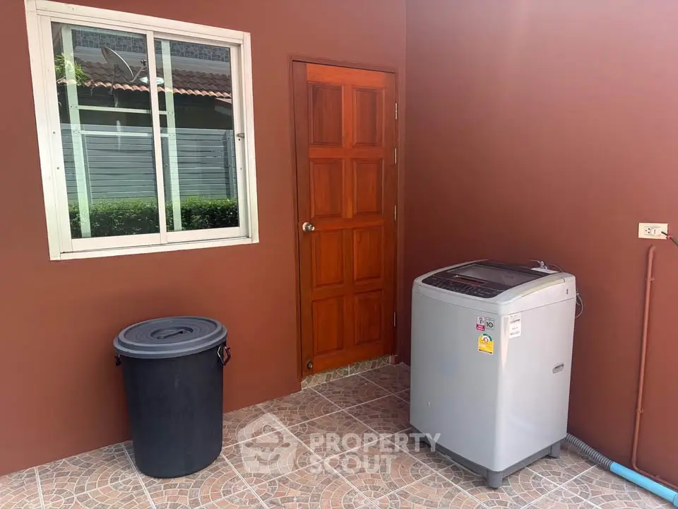 Charming outdoor laundry area with washing machine and storage bin