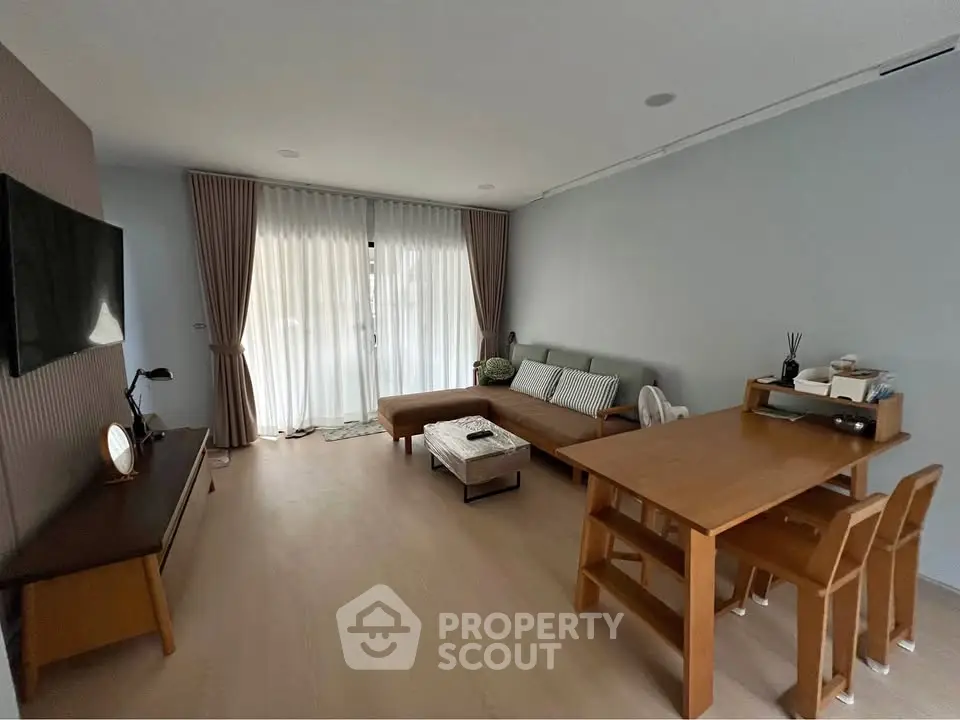 Modern living room with natural light, wooden furniture, and cozy decor