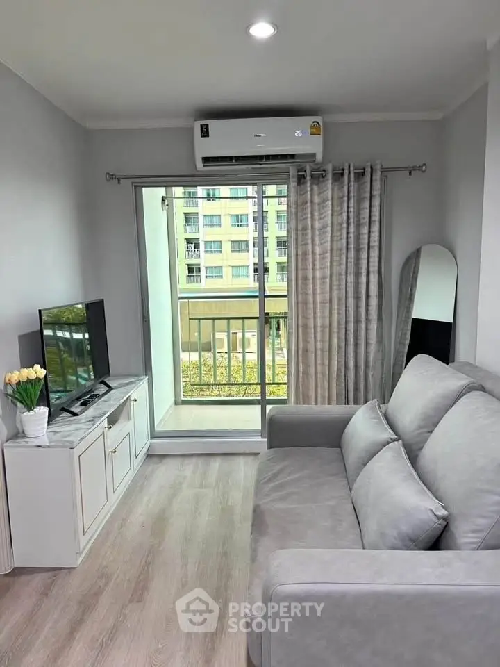 Modern living room with balcony view, featuring sleek furniture and natural light.