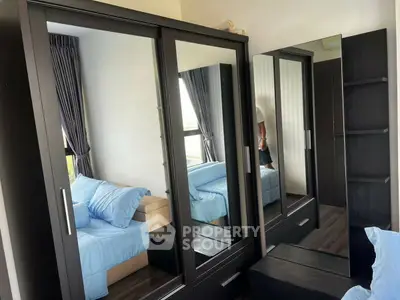 Modern bedroom with mirrored wardrobe and cozy blue bedding