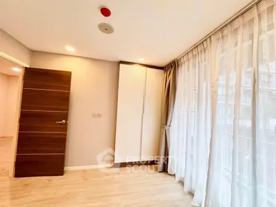 Spacious bedroom with large windows and modern design in a luxury apartment.