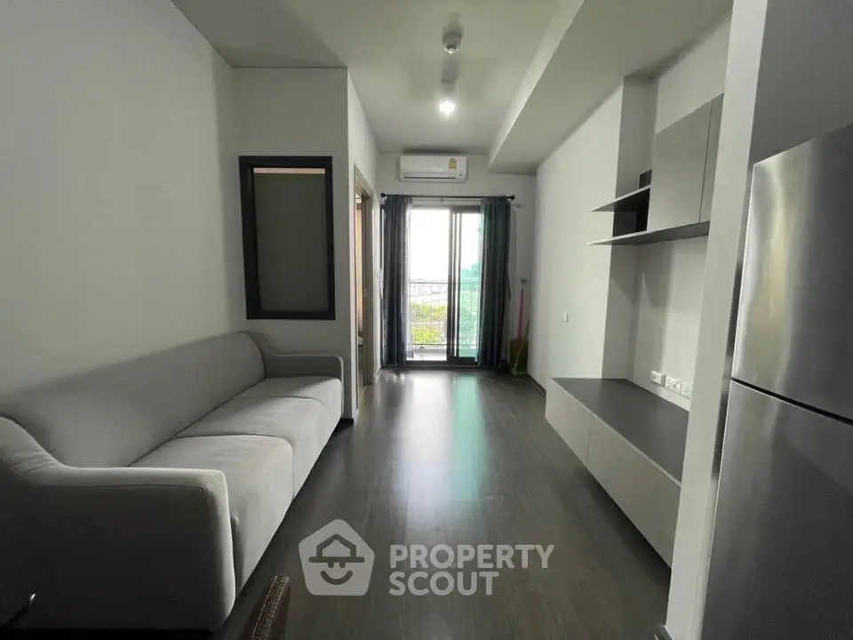 Modern living room with sleek design and balcony view in a contemporary apartment.