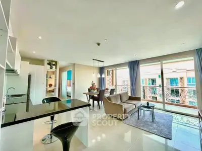 Spacious modern living room with open kitchen and large windows offering a bright and airy atmosphere.