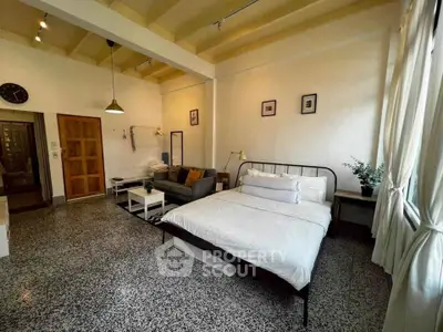Spacious studio apartment with modern decor and large windows for natural light.