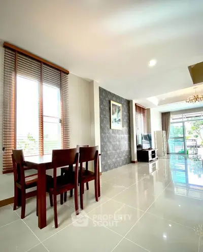 Spacious modern living room with elegant dining area and large windows.