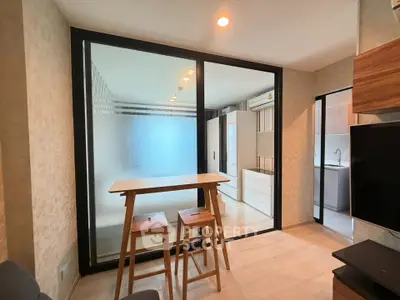 Modern living room with glass partition and stylish furniture in a contemporary apartment.