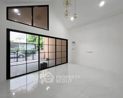 Spacious modern living room with large windows and elegant lighting