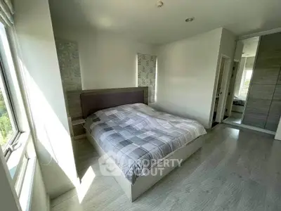 Spacious bedroom with large windows and modern decor, perfect for relaxation and comfort.