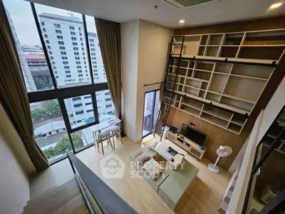 Stunning loft apartment with high ceilings and large windows offering city views, featuring a cozy living area and modern decor.