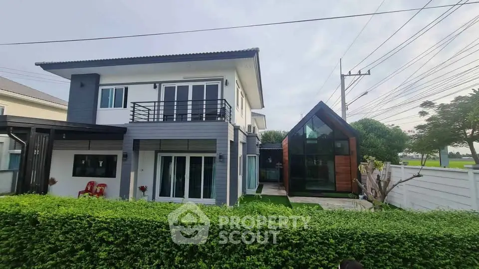 Modern two-story house with lush green garden and unique glass extension