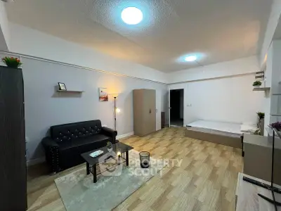 Spacious studio apartment with modern furnishings and wooden flooring, ideal for urban living.