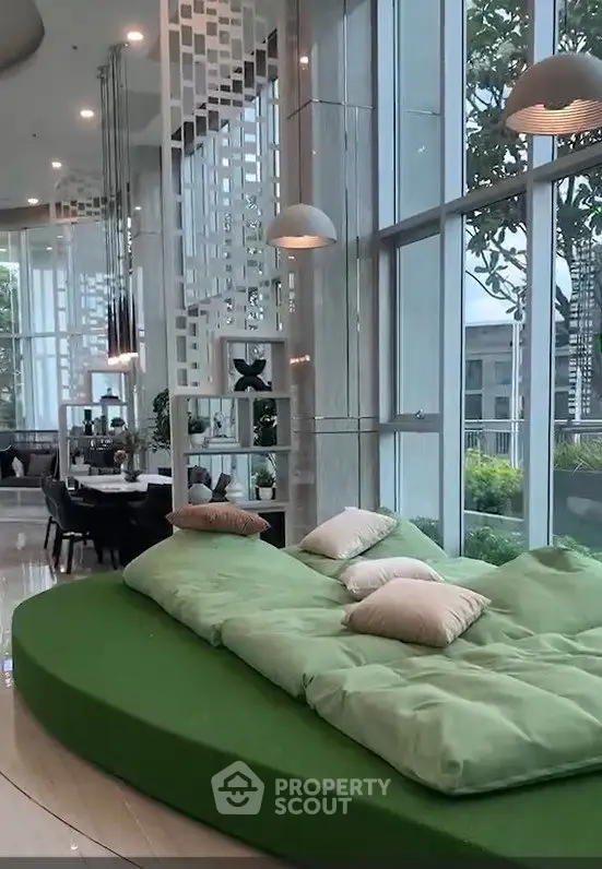 Luxurious modern living room with large windows and stylish green seating area.