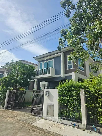 Charming two-story house with lush greenery and modern design in a serene neighborhood.