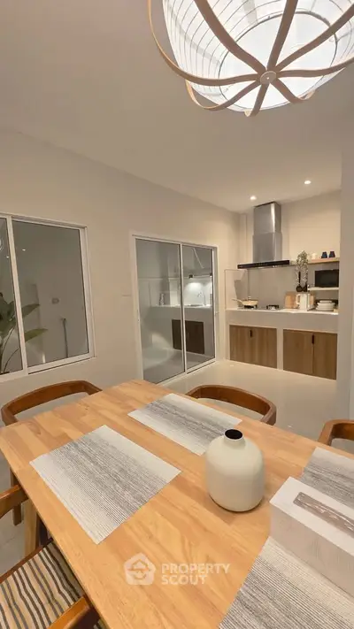 Modern dining area with wooden table and open kitchen layout