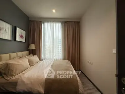Luxurious bedroom with elegant decor and large window offering city views, perfect for relaxation and comfort.
