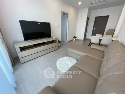 Modern living room with sleek furniture and flat-screen TV, perfect for relaxation and entertainment.