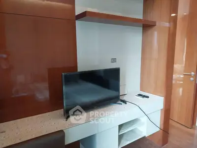 Modern living room with sleek TV setup and wooden accents