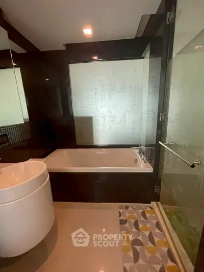 Modern bathroom with sleek design and elegant bathtub, featuring stylish glass shower doors.