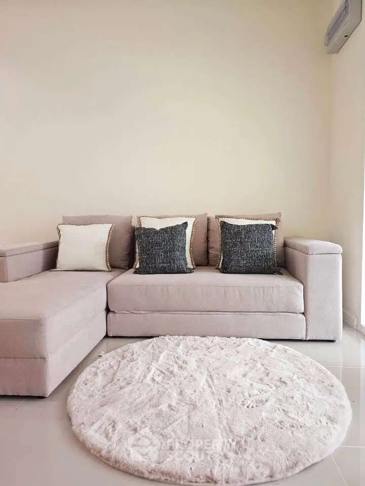 Cozy living room with stylish beige sofa and plush round rug