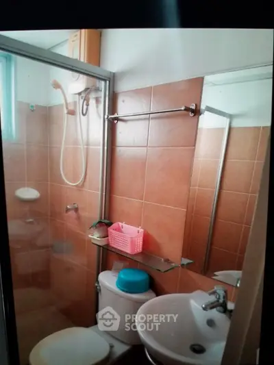 Compact bathroom with shower and modern fixtures in cozy apartment.