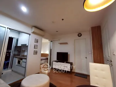 Modern apartment interior with open layout, featuring cozy living room and adjacent kitchen area.