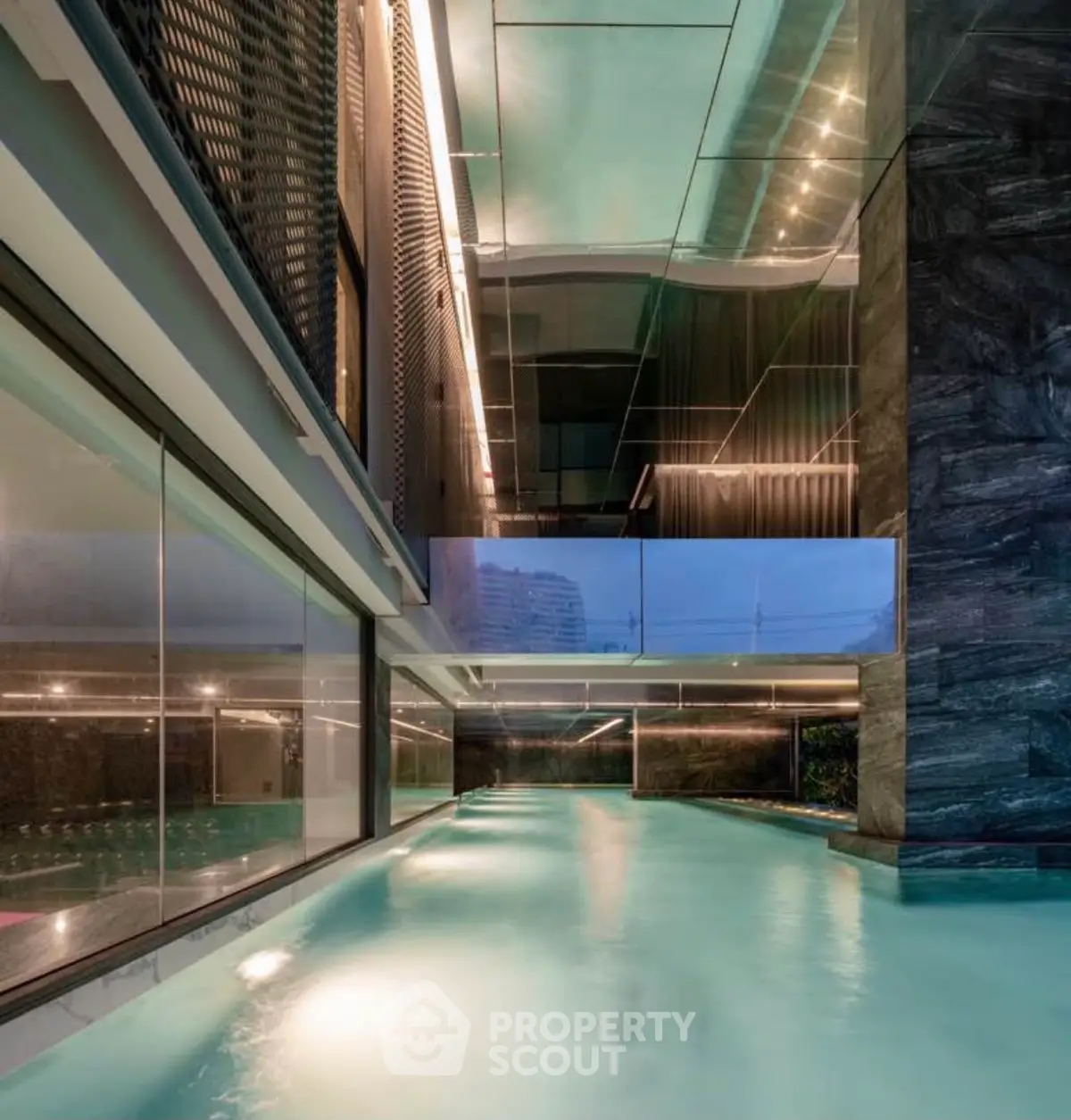 Luxurious indoor pool with modern design and ambient lighting in upscale property.