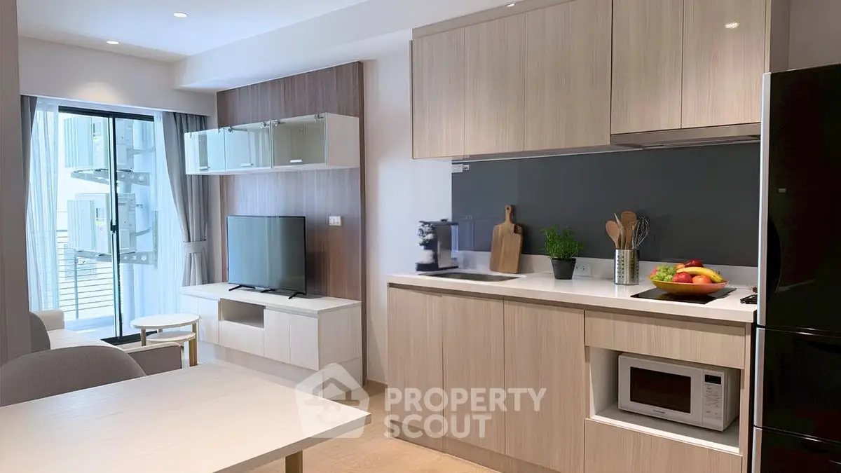 Modern open-layout kitchen and living room with sleek cabinetry and natural light.