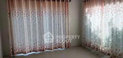 Spacious room with large windows and elegant polka dot curtains, perfect for natural light and modern decor.