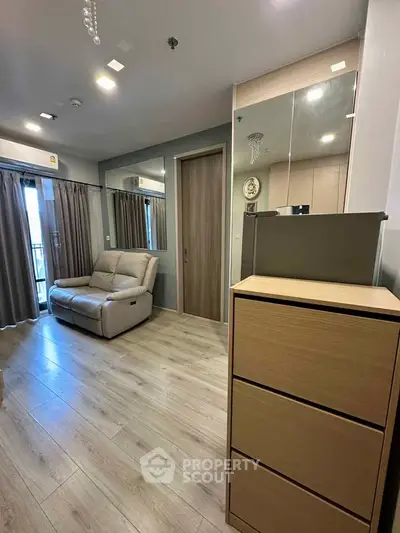 Modern living room with sleek wooden flooring and cozy seating area.