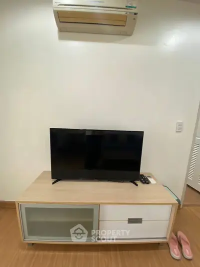 Modern living room with sleek TV stand and air conditioning unit, perfect for cozy entertainment.