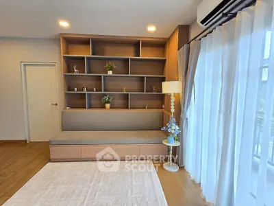 Modern living room with built-in shelving and large window