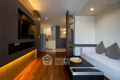 Modern living room with sleek design and open kitchen layout, featuring hardwood floors and stylish decor.
