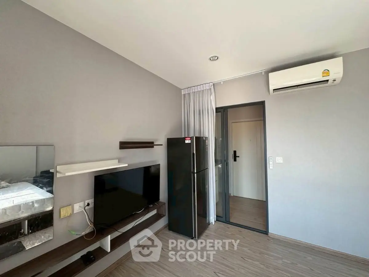 Modern living room with sleek TV unit and air conditioning in stylish apartment.