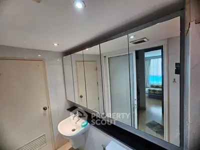 Modern bathroom with large mirror and sleek sink in a stylish apartment.