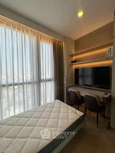 Modern bedroom with large window, stylish desk, and wall-mounted TV in a high-rise apartment.