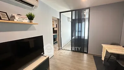 Modern apartment interior with sleek design and glass partition, featuring a cozy living area and stylish decor.