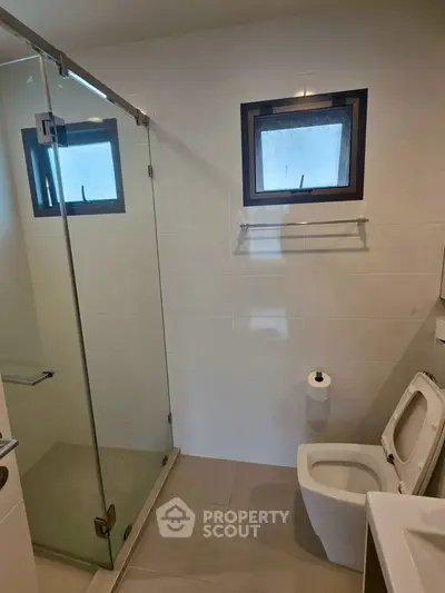 Modern bathroom with glass shower and sleek fixtures in a contemporary home.