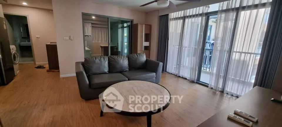 Spacious living room with modern decor and large windows in a stylish apartment.