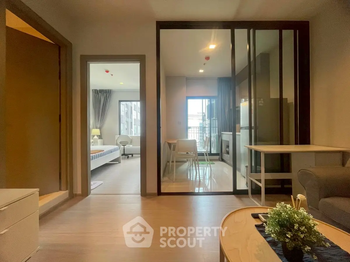 Modern apartment interior with open layout, featuring a cozy living area and a bright bedroom.