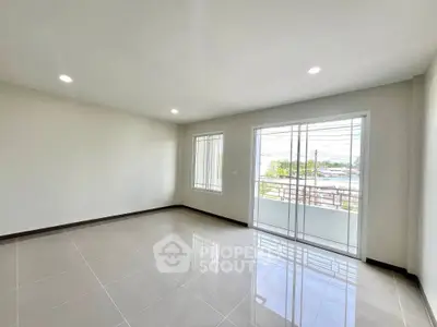 Spacious empty room with large windows and balcony access, perfect for customization.