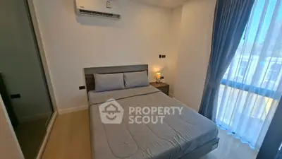 Modern bedroom with air conditioning and natural light, featuring a comfortable bed and stylish decor.