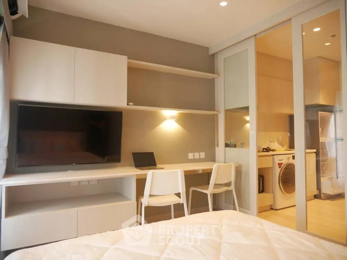 Modern bedroom with study area and in-unit laundry, featuring sleek design and ample natural light.