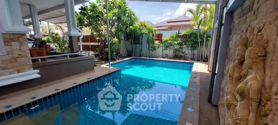 Luxurious private pool with tropical garden and elegant stone sculptures