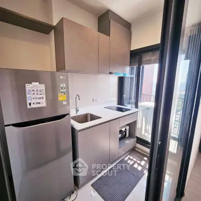 Modern kitchen with sleek cabinetry and balcony view in urban apartment