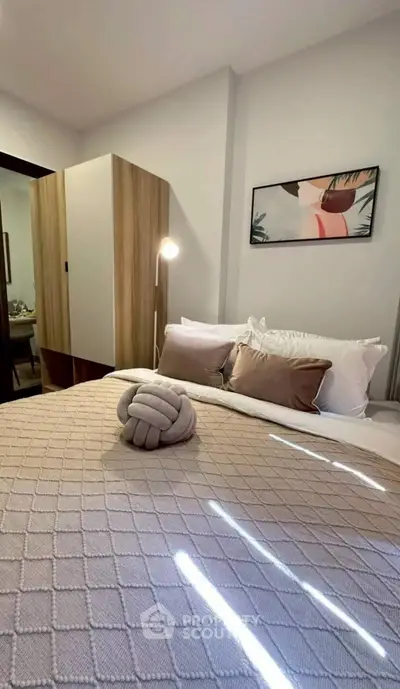 Cozy bedroom with modern decor and soft lighting, featuring a stylish bed and elegant artwork.