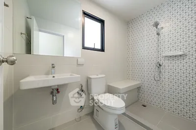 Modern bathroom with geometric tile design and sleek fixtures