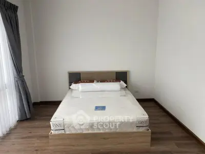 Spacious bedroom with new mattress and elegant wooden flooring
