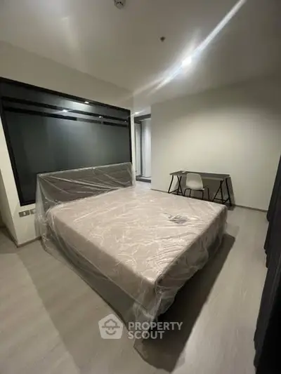 Modern bedroom with large window and minimalist furniture in a sleek apartment.