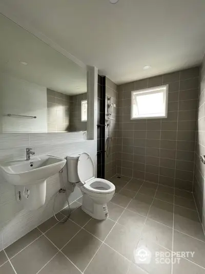 Spacious modern bathroom with sleek tile design and natural light