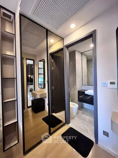 Modern bathroom with sleek design, featuring a large mirror and stylish fixtures.